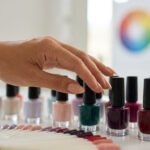 Main choisissant parmi une sélection de flacons de vernis à ongles et un nuancier de couleurs.