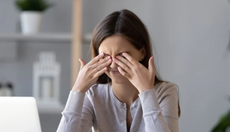 Femme se mettant les doigt sur les yeux à cause d'une migraine