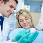Dentiste montrant un implant pendant des soins dentaires