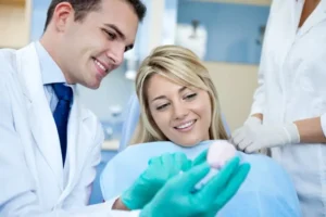 Dentiste montrant un implant pendant des soins dentaires