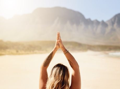 Beach, woman and meditation for peace, calm and mental health in Australia. Seaside, female person and back with zen on upward salute pose for balance, spirituality and faith on self care or wellness.